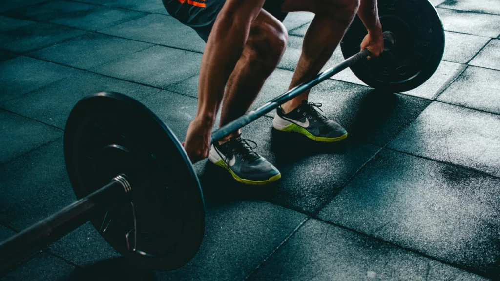 Close-up of a person performing a barbell deadlift as part of a structured strength training session