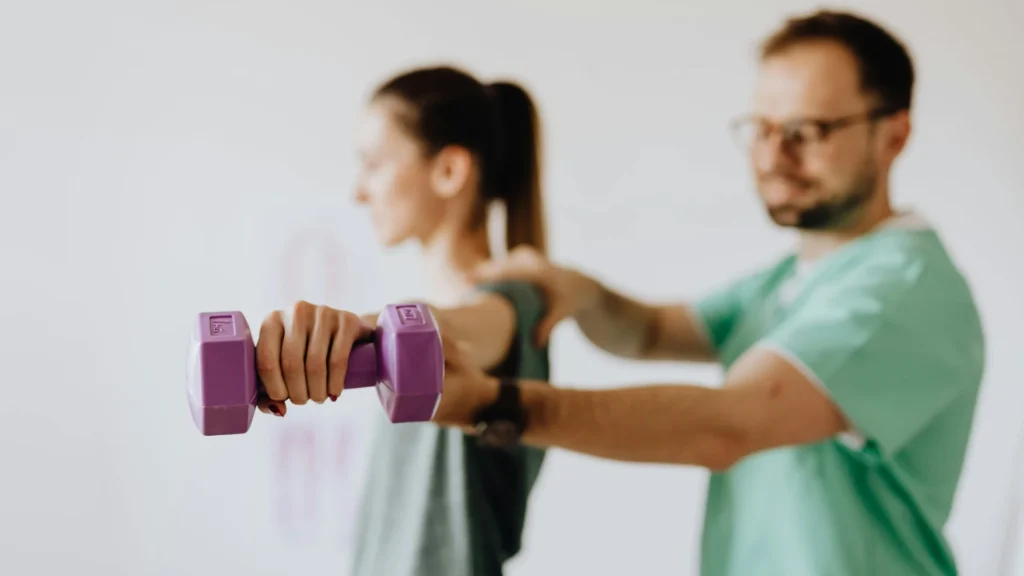 Exercise physiologist guiding a client through a supervised strength training exercise.